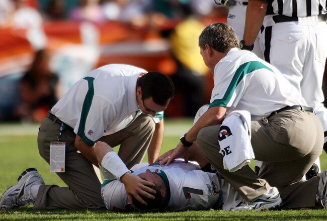 MIAMI - NOVEMBER 14:  Quarterback Chad Henne #7 of the Miami Dolphins is helped on the field  against the Tennessee Titans at Sun Life Stadium on November 14, 2010 in Miami, Florida.  (Photo by Marc Serota/Getty Images)