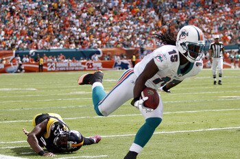 MIAMI - OCTOBER 24:  Receiver Davone Bess #15 scores a touchdown against linebacker Lawrence Timmons #94 of the Pittsburgh Steelers  at Sun Life Stadium on October 24, 2010 in Miami, Florida.  (Photo by Marc Serota/Getty Images)