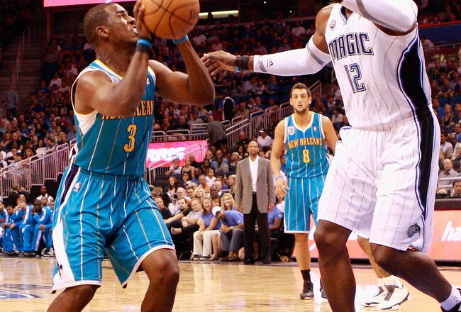 ORLANDO, FL - OCTOBER 10:  Chris Paul #3 of the New Orleans Hornets attempts a shot against Dwight Howard #12 of the Orlando Magic during the game at Amway Arena on October 10, 2010 in Orlando, Florida. NOTE TO USER: User expressly acknowledges and agrees