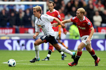 BOLTON, ENGLAND - SEPTEMBER 26:  Stuart Holden of Bolton Wanderers is challenged by Paul Scholes of Manchester United during the Barclays Premier League match between Bolton Wanderers and Manchester United at the Reebok Stadium on September 26, 2010 in Bo