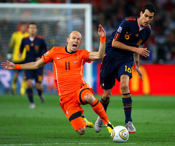 JOHANNESBURG, SOUTH AFRICA - JULY 11:  Arjen Robben of the Netherlands falls to the ground after being tackled by Sergio Busquets of Spain during the 2010 FIFA World Cup South Africa Final match between Netherlands and Spain at Soccer City Stadium on July