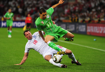 CAPE TOWN, SOUTH AFRICA - JUNE 18:  Jamie Carragher of England tackles Karim Matmour of Algeria during the 2010 FIFA World Cup South Africa Group C match between England and Algeria at Green Point Stadium on June 18, 2010 in Cape Town, South Africa.  (Pho