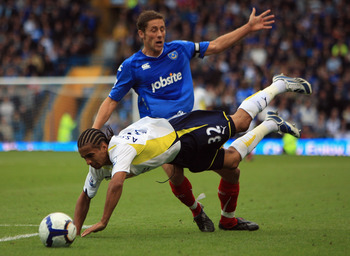 PORTSMOUTH, ENGLAND - OCTOBER 17:  Benoit Assou Ekotto of Tottenham Hotspur clashes with Michael Brown of Portsmouth during the Barclays Premier League match between Portsmouth and Tottenham Hotspur at Fratton Park on October 17, 2009 in Portsmouth, Engla