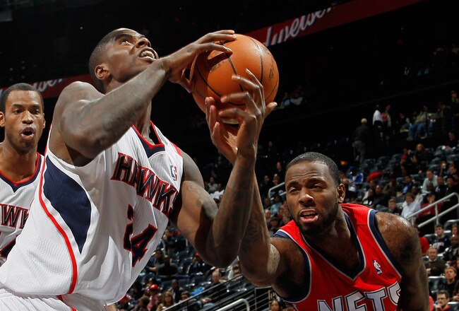 ATLANTA, GA - DECEMBER 07:  Marvin Williams #24 of the Atlanta Hawks is fouled by Damion James #10 of the New Jersey Nets at Philips Arena on December 7, 2010 in Atlanta, Georgia.  NOTE TO USER: User expressly acknowledges and agrees that, by downloading