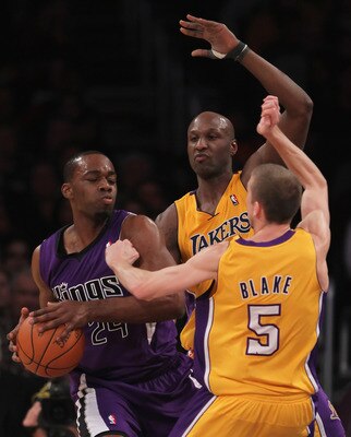LOS ANGELES, CA - DECEMBER 03:  (L-R) Carl Landry #24 of the Sacramento Kings is defended by Lamar Odom #7 and Steve Blake #5 of the Los Angeles Lakers during the first half at Staples Center on December 3, 2010 in Los Angeles, California. The Lakers defe