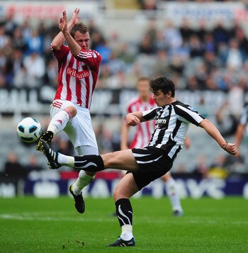 NEWCASTLE UPON TYNE, ENGLAND - SEPTEMBER 26:  Joey Barton of Newcastle United is challenged by Glen Whelan of Stoke City during the Barclays Premier League match between Newcastle United and Stoke City at St James' Park on September 26, 2010 in Newcastle 