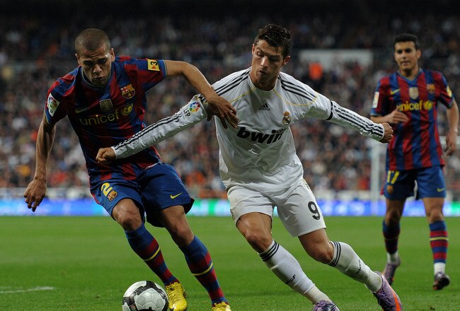 MADRID, SPAIN - APRIL 10:  Cristiano Ronaldo (R) of Real Madrid fights for the ball with Daniel Alves of FC Barcelona during the La Liga match between Real Madrid and Barcelona at the Estadio Santiago Bernabeu on April 10, 2010 in Madrid, Spain. Barcelona