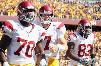 MINNEAPOLIS - SEPTEMBER 18:  Quarterback Matt Barkley #7 of the USC Trojans, flanked by Tyron Smith #70 and Ronald Johnson #83, runs off the field after the Trojans scored a touchdown during the first half of the game against the Minnesota Golden Gophers