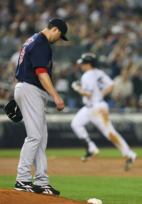 NEW YORK - SEPTEMBER 24:  Josh Beckett #19 of the Boston Red Sox walks back to the mound after allowing a home run from Mark Teixeira #25 (background) of the New York Yankees  in the sixth inning on September 24, 2010 at Yankee Stadium in the Bronx boroug