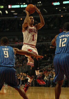 CHICAGO, IL - DECEMBER 01: Derrick Rose #1 of the Chicago Bulls shoots against Rashard Lewis #9 and Dwight Howard #12 of the Orlando Magic at the United Center on December 1, 2010 in Chicago, Illinois. The Magic defeated the Bulls 107-78. NOTE TO USER: Us