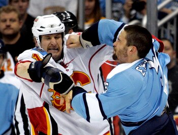 PITTSBURGH - NOVEMBER 27:  Tim Jackman #15 of the Calgary Flames and Deryk Engelland #5 of the Pittsburgh Penguins mix it up at Consol Energy Center on November 27, 2010 in Pittsburgh, Pennsylvania.  (Photo by Justin K. Aller/Getty Images)