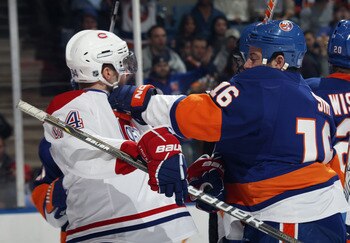 UNIONDALE, NY - OCTOBER 29: Tom Pyatt #94 of the Montreal Canadiens is hit by Jon Sim #16 of the New York Islanders at the Nassau Coliseum on October 29, 2010 in Uniondale, New York. (Photo by Bruce Bennett/Getty Images)