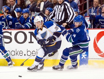 VANCOUVER, CANADA - DECEMBER 5: Alexandre Burrows #14 of the Vancouver Canucks checks Matt D'Agostini #36 of the St Louis Blues off the puck during the third period in NHL action on December 05, 2010 at Rogers Arena in Vancouver, BC, Canada.  (Photo by Ri