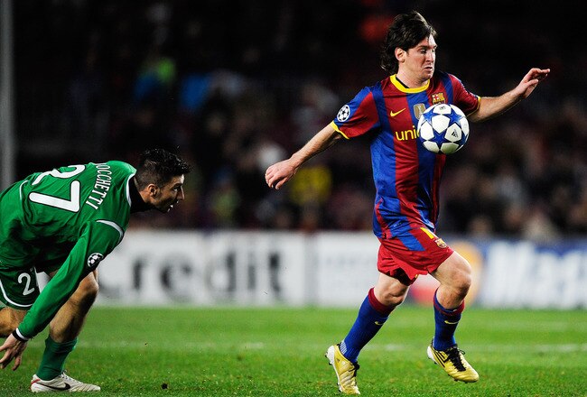 BARCELONA, SPAIN - DECEMBER 07:  Salvatore Bocchetti of Rubin Kazan looks to Lionel Messi of Barcelona as he controls the ball during the Csampions League match between Barcelona and Rubin Kazan at Camp Nou Stadiumon December 7, 2010 in Barcelona, Spain.