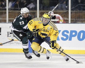 ANN ARBOR, MI - DECEMBER 11: Carl Hagelin #12 of the Michigan Wolverines controls the puck in front of Luke Glendening #23 of the Michigan State Spartans at Michigan Stadium on December 11, 2010 in Ann Arbor, Michigan.  (Photo by Gregory Shamus/Getty Imag