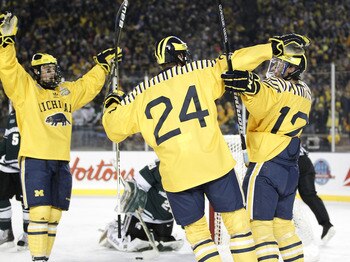 ANN ARBOR, MI - DECEMBER 11:  Carl Hagelin #12 of the Michigan Wolverines celebrates his third period goal with Jon Merrill #24 and Kevin Lynch #11 while playing the Michigan State Spartans at Michigan Stadium on December 11, 2010 in Ann Arbor, Michigan.