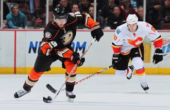 ANAHEIM, CA - DECEMBER 10:  Joffrey Lupul #19 of the Anaheim Ducks is pursued by Curtis Glencross #40 of the Calgary Flames for the puck in the third period at the Honda Center on December 10, 2010 in Anaheim, California. The Ducks defeated the Flames 3-2