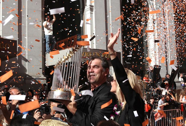 SAN FRANCISCO - NOVEMBER 03:  San Francisco Giants manager Bruce Bochy carries the World Series trophy as he rides in a vintage car during the Giants' vicotry parade on November 3, 2010 in San Francisco, California. Thousands of Giants fans lined the stre