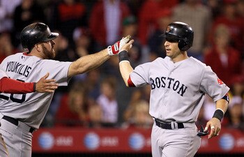 ANAHEIM, CA - JULY 27: Marco Scutaro #30 of the Boston Red Sox is greeted by on deck batter Kevin Youkilis #20 after scoring  run in the seventh inning against the Los Angeles Angels of Anaheim on July 27, 2010 at Angel Stadium in Anaheim, California. (Ph