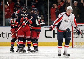 NEW YORK, NY - DECEMBER 12:  The New York Rangers celebrate their seventh goal as Scott Hannan #23 of the Washington Capitals skates back to the bench on December 12, 2010 at Madison Square Garden in New York City. The Rangers defeated the Capitals 7-0.
