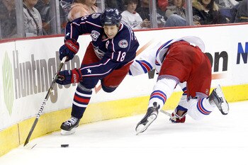 COLUMBUS,OH - DECEMBER 11:  R.J. Umberger #18 of the Columbus Blue Jackets slips past Marc Staal #18 of the New York Rangers to get to a loose puck during the second period on December 11, 2010 at Nationwide Arena in Columbus, Ohio.  (Photo by John Griesh