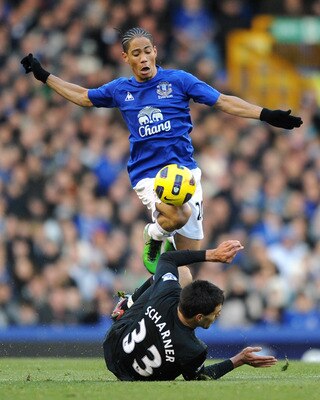 LIVERPOOL, ENGLAND - NOVEMBER 27:  Steven Pienaar of Everton hurdles the challenge of Paul Scharner of West Bromwich Albion during the Barclays Premier League match between Everton and West Bromwich Albion at Goodison Park on November 27, 2010 in Liverpoo