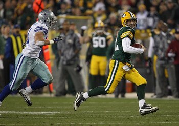 GREEN BAY, WI - NOVEMBER 07: Aaron Rodgers #12 of the Green Bay Packers runs for a first down pursued by Keith Brooking #51 of the Dallas Cowboys at Lambeau Field on November 7, 2010 in Green Bay, Wisconsin. The Packers defeated the Cowboys 45-7.  (Photo