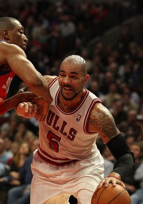 CHICAGO, IL - DECEMBER 21: Carlos Boozer #5 of the Chicago Bulls drives against Tony Battie #4 of the Philadelphia 76ers at the United Center on December 21, 2010 in Chicago, Illinois. The Bulls defeated the 76ers 121-76. NOTE TO USER: User expressly ackn