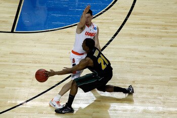 BUFFALO, NY - MARCH 19:  Garvey Young #21 of the Vermont Catamounts passes against Andy Rautins #1 of the Syracuse Orange during the first round of the 2010 NCAA men's basketball tournament at HSBC Arena on March 19, 2010 in Buffalo, New York.  (Photo by