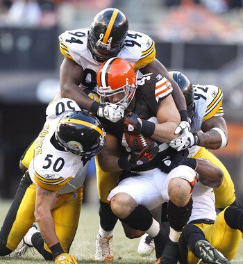 CLEVELAND, OH - JANUARY 02:  Defenders Larry Foote #50, Lawrence Timmons #94 and James Harrison #92 of the Pittsburgh Steelers tackle tailback Peyton Hillis #40 of the Cleveland Browns at Cleveland Browns Stadium on January 2, 2011 in Cleveland, Ohio.  (P