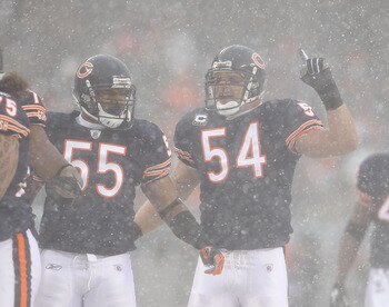 CHICAGO, IL - DECEMBER 12: Brian Urlacher #54 of the Chicago Bears calls a defensive play as teammate Lance Briggs #55 moves into position against the New England Patriots at Soldier Field on December 12, 2010 in Chicago, Illinois. The Patriots defeated t