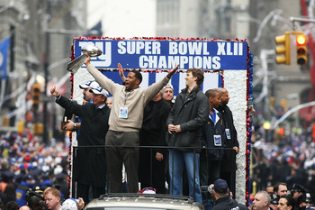 NEW YORK - FEBRUARY 05:  Mayor of New York Michael Bloomberg (L), Michael Strahan (C) and Eli Manning of the New York Giants ride in a float along Broadway, also known as 'The Canyon of Heroes' during Super Bowl XLII victory parade in New York City, New Y