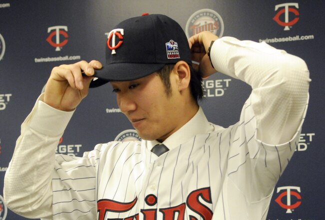 MINNEAPOLIS, MN - DECEMBER 18: Tsuyoshi Nishioka #1 of the Minnesota Twins puts on his Twins hats for members of the media during a press conference on December 18, 2010 at Target Field in Minneapolis, Minnesota. (Photo by Hannah Foslien /Getty Images)