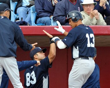 Top Yankees Prospect Jesus Montero (#83) high-fiving Alex Rodriguez (#13) in a Spring Training game