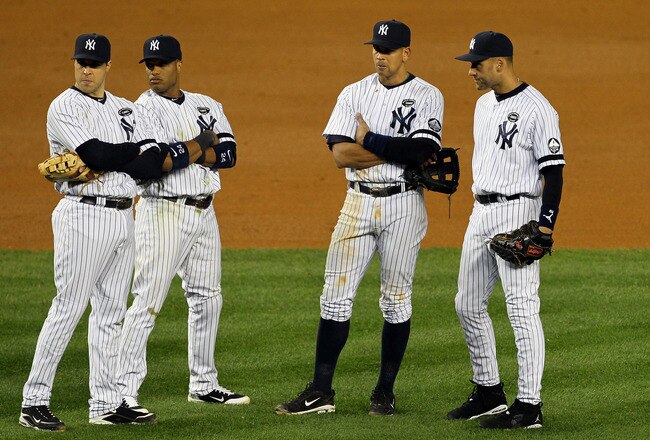 NEW YORK - OCTOBER 18:  Mark Teixeira #25, Robinson Cano #24, Alex Rodriguez #13 and Derek Jeter #2 of the New York Yankees look on during a pitching change against the Texas Rangers in Game Three of the ALCS during the 2010 MLB Playoffs at Yankee Stadium