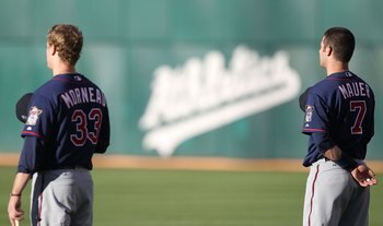 OAKLAND, CA - JUNE 04:  Justin Morneau #33 and Joe Mauer #7 of the Minnesota Twins look on against the Oakland Athletics during an MLB game at the Oakland-Alameda County Coliseum on June 4, 2010 in Oakland, California.  (Photo by Jed Jacobsohn/Getty Image