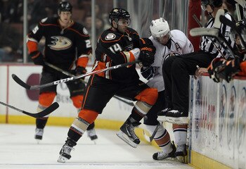 ANAHEIM, CA - JANUARY 16:  Maxim Lapierre #14 of the Anaheim Ducks hits Tom Gilbert #77 of the Edmonton Oilers into the boards in the third period at the Honda Center on January 16, 2011 in Anaheim, California. The Ducks defeated the Oilers 3-2.  (Photo b
