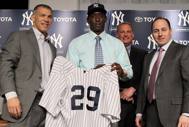 NEW YORK, NY - JANUARY 19:  Rafael Soriano (2nd L) of the New York Yankees poses for a photograph during his press conference with manager Joe Girard (L)i, president Randy Levine (2nd R) and general manager Brian Cashman, and COO Lonn Trost on January 19,
