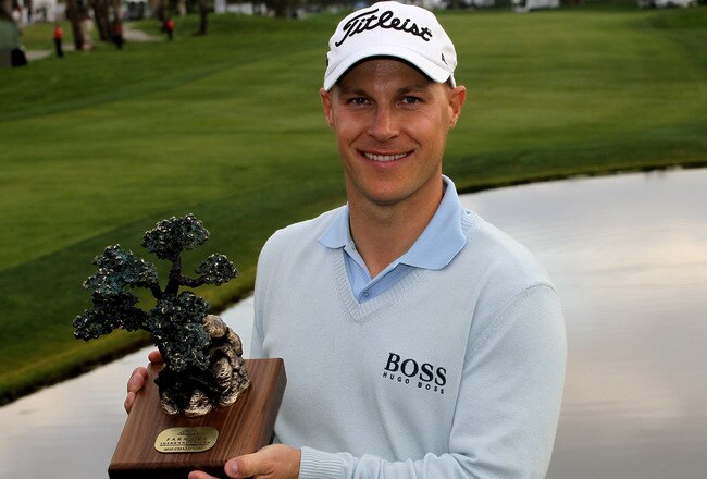 LA JOLLA, CA - JANUARY 31:  Ben Crane poses with the trophy on the 18th green on the South Course at Torrey Pines Golf Course after the final round of the Farmers Insurance Open on January 31, 2010 in La Jolla, California. (Photo by Stephen Dunn/Getty Ima