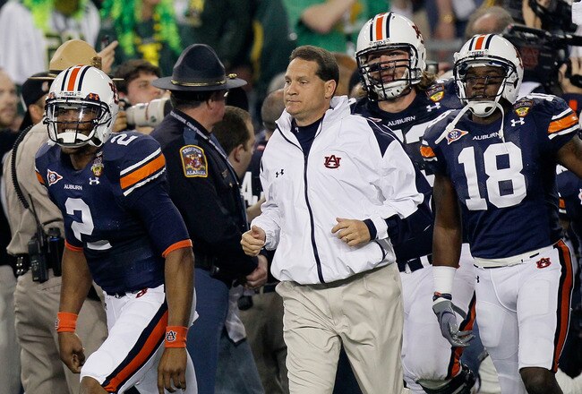 GLENDALE, AZ - JANUARY 10:  Cameron Newton #2, Head coach Gene Chizik, Lee Ziemba #73 and Kodi Burns #18 of the Auburn Tigers react on the sideline against the Oregon Ducks during the Tostitos BCS National Championship Game at University of Phoenix Stadiu