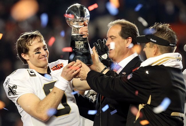 MIAMI GARDENS, FL - FEBRUARY 07:  Head coach Sean Payton of the New Orleans Saints passes quarterback Drew Brees #9 the Vince Lombardi trophy after defeating the Indianapolis Colts during Super Bowl XLIV on February 7, 2010 at Sun Life Stadium in Miami Ga
