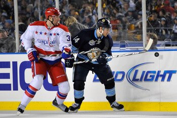 PITTSBURGH, PA - JANUARY 01:  Chris Kunitz #14 of the Pittsburgh Penguins battles for control of the puck against David Steckel #39 of the Washington Capitals during the 2011 NHL Bridgestone Winter Classic at Heinz Field on January 1, 2011 in Pittsburgh,