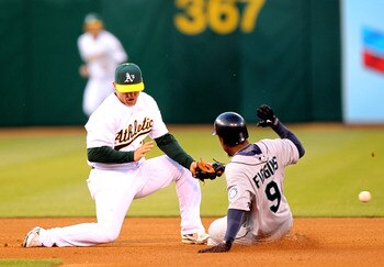 OAKLAND, CA - APRIL 05:  Chone Figgins #9 of the Seattle Mariners safely steals second base as the ball gets past Cliff Pennington #2 of the Oakland Athletics on Opening Day at the Oakland-Alameda County Coliseum on April 5, 2010 in Oakland, California.