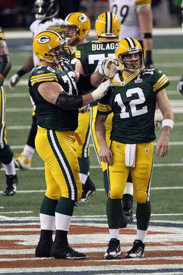 ARLINGTON, TX - FEBRUARY 06: Chad Clifton #76 of the Green Bay Packers fixes teammate Aaron Rodgers #12 shoulder pad during Super Bowl XLV against the Pittsburgh Steelers at Cowboys Stadium on February 6, 2011 in Arlington, Texas.  (Photo by Streeter Leck
