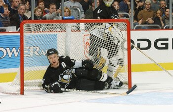 WASHINGTON - DECEMBER 11:  Defenseman Darius Kasparaitis #11 of the Pittsburgh Penguins ends up in his own goal after rough defensive play during the NHL game against the Washington Capitals at the MCI Center in Washington D.C. on December 11, 2001.  The
