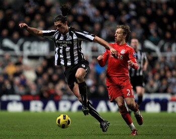NEWCASTLE UPON TYNE, ENGLAND - DECEMBER 11:  Andy Carroll of Newcastle United competes with Lucas of Liverpool during the Barclays Premier League match between Newcastle United and Liverpool at St James' Park on December 11, 2010 in Newcastle, England.  (