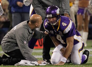 MINNEAPOLIS, MN - DECEMBER 05:  Brett Favre #4 of the Minnesota Vikings is assisted by medical staff against the Buffalo Bills defense at the Mall of America Field at the Hubert H. Humphrey Metrodome on December 5, 2010 in Minneapolis, Minnesota.  (Photo