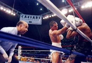 1 Mar 1997:  Hector 'Macho' Camacho (center) pins Sugar Ray Leonard to the ropes as referee Joe Cotez looks on during a bout in Atlantic City, New Jersey.  Camacho won the fight with a TKO in the fifth round. Mandatory Credit: Al Bello  /Allsport