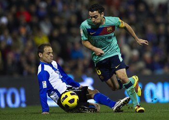ALICANTE, SPAIN - JANUARY 29:  Xavi Hernandez (R) of Barcelona duels for the ball with Farinos of Hercules during the la Liga match between Hercules and Barcelona at Estadio Jose Rico Perez on January 29, 2011 in Alicante, Spain. Barcelona won 0-3.  (Phot