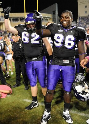 FORT WORTH, TX - OCTOBER 16:  Defensive end Wayne Daniels #96 and Jeff Olson #62 of the TCU Horned Frogs celebrate a win against the BYU Cougars as fans are detained by Fort Worth Police at Amon G. Carter Stadium on October 16, 2008 in Fort Worth, Texas.
